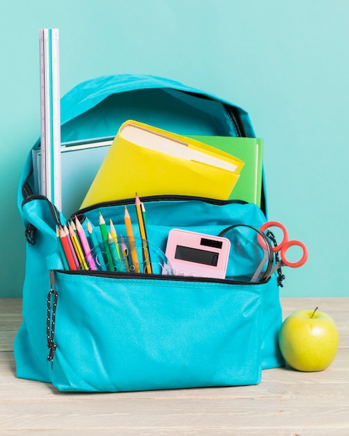 Bezpłatne zdjęcie niebieska torba szkolna z niezbędnymi dostawami