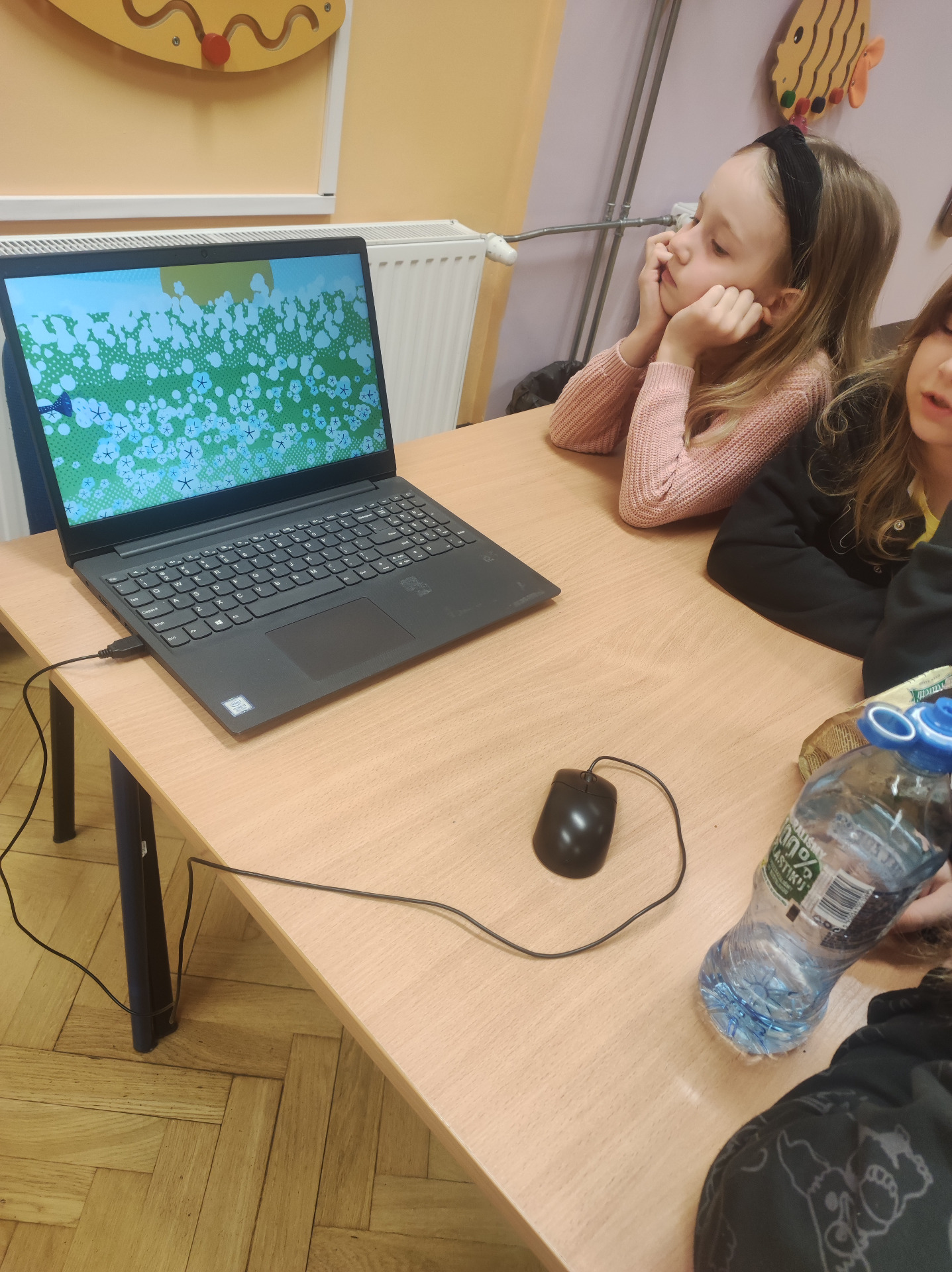 Uczniowie oglądają animację na laptopie dotyczącą dostępu do wody na świecie.