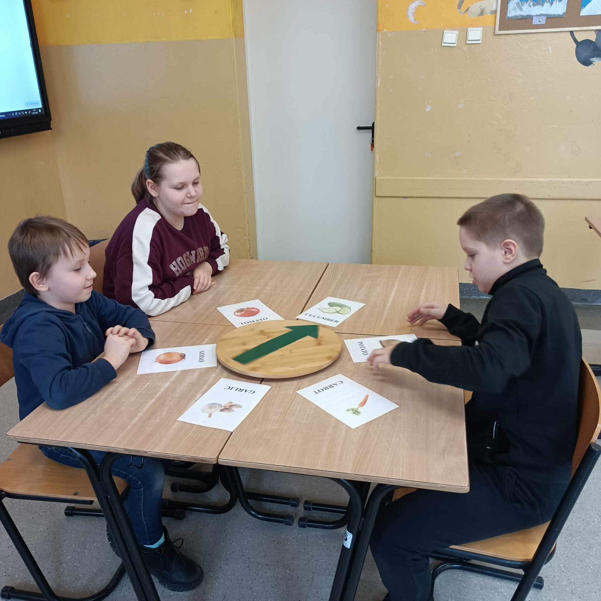 3 uczniów gra w grę dotyczącą warzyw