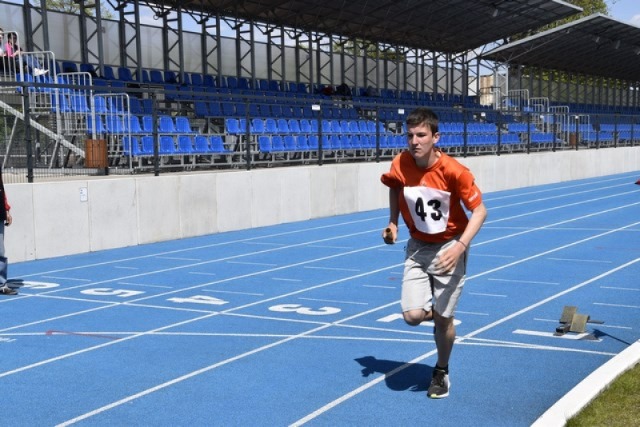 Uczeń biegnie na bieżni na stadionie sportowym