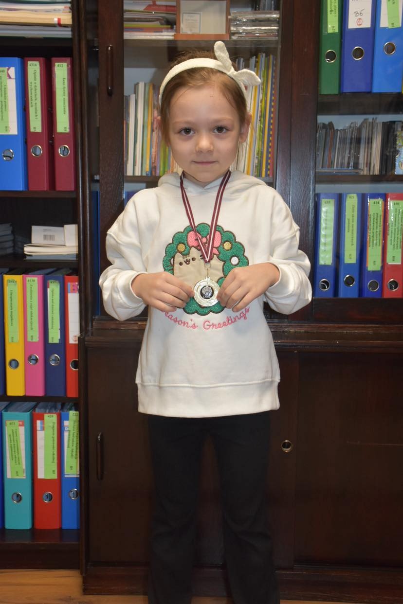 Emilka ze złotym medalem za zwycięstwo w zawodach.